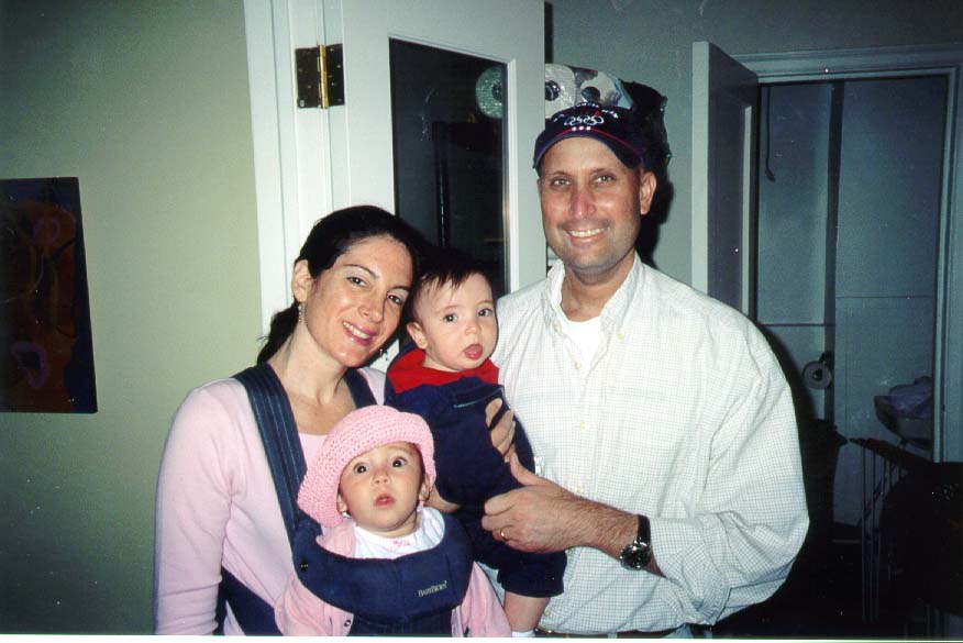A photo of a man and woman with two infant children.